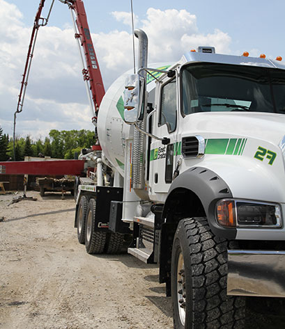 An image of a concrete truck pouring ready-mix concrete at a construction site for concrete recycling purposes.