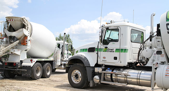 An image of two concrete trucks at a construction site.
